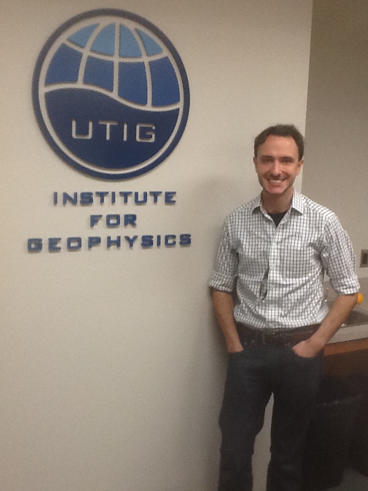 Dusty Schroeder poses by the UTIG logo