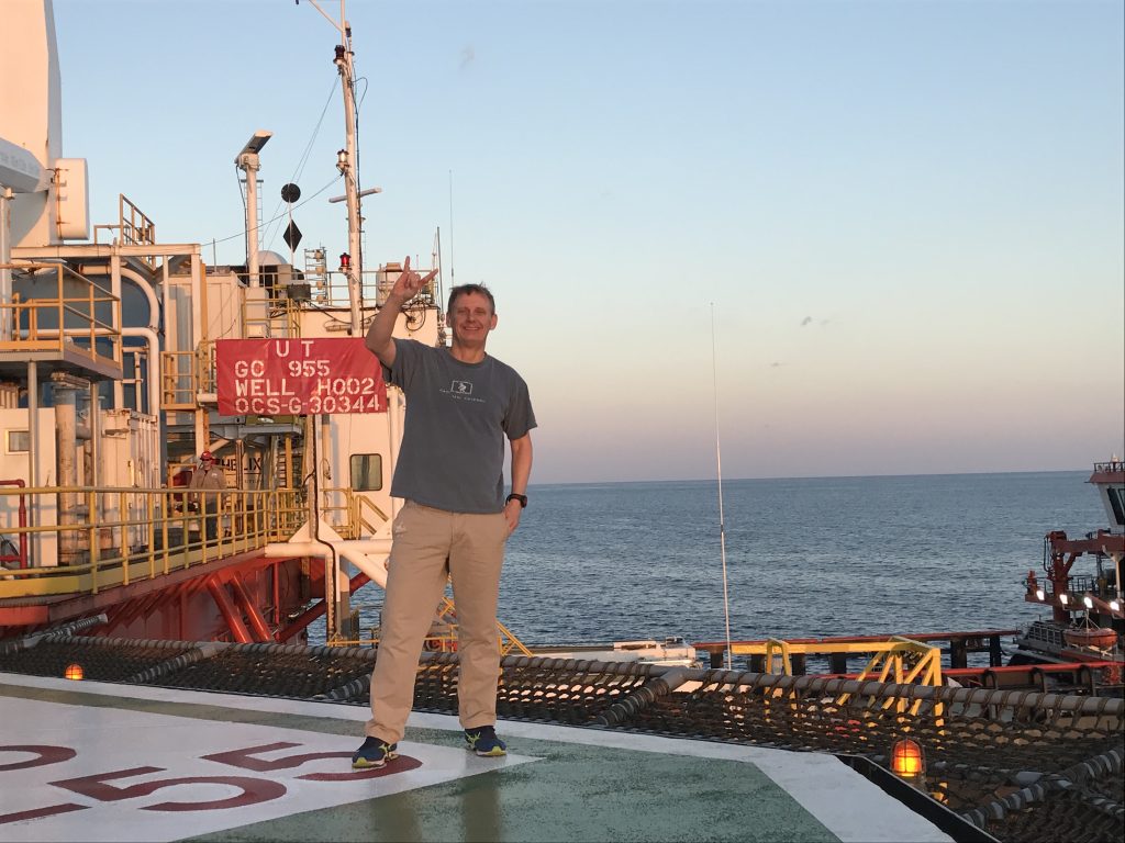 Flemings on the helipad with the rig and the ocean behind him.