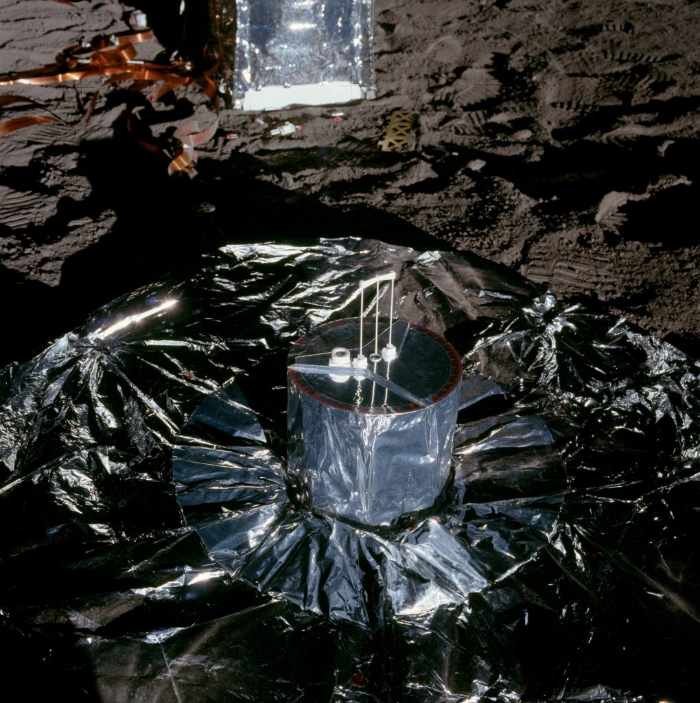 Photo of an instrument covered in a metal foil blanket on the moon's surface.