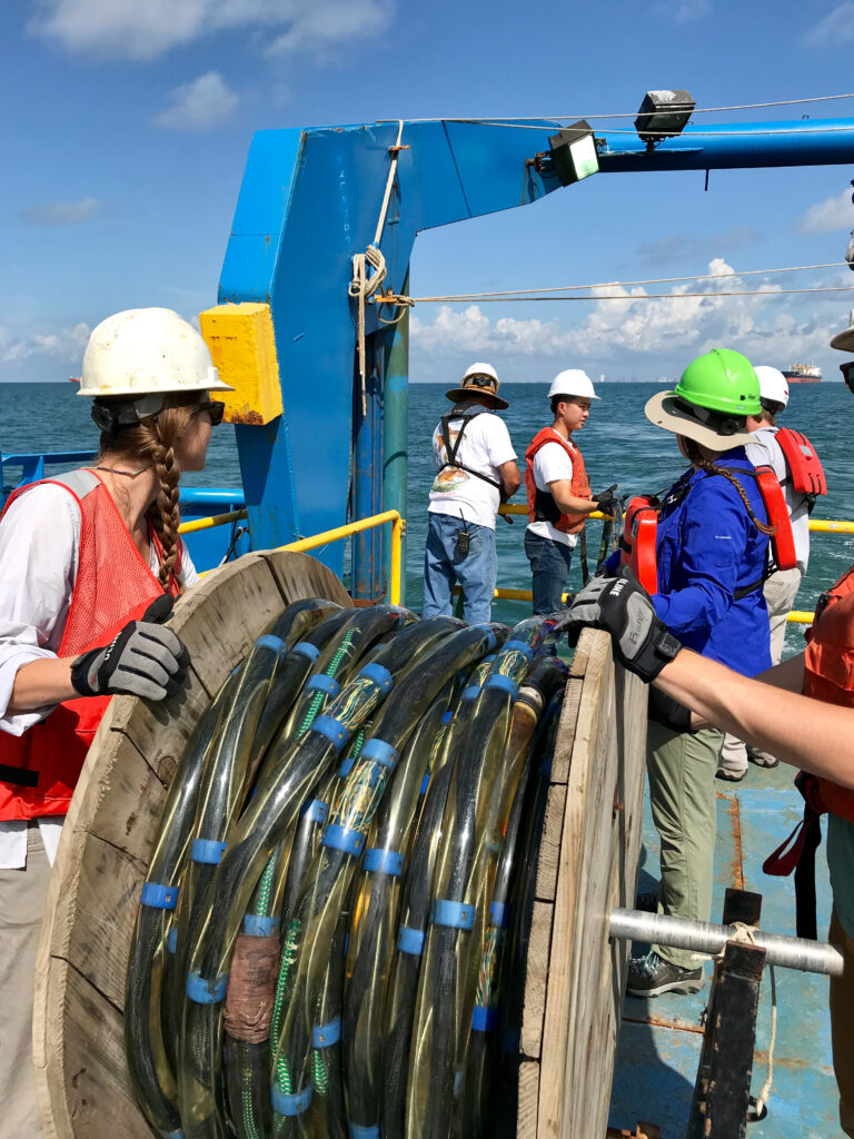 Students unrolling a seismic streamer from aft of scientific research vessel during UTs Marine Geology and Geophysics field class