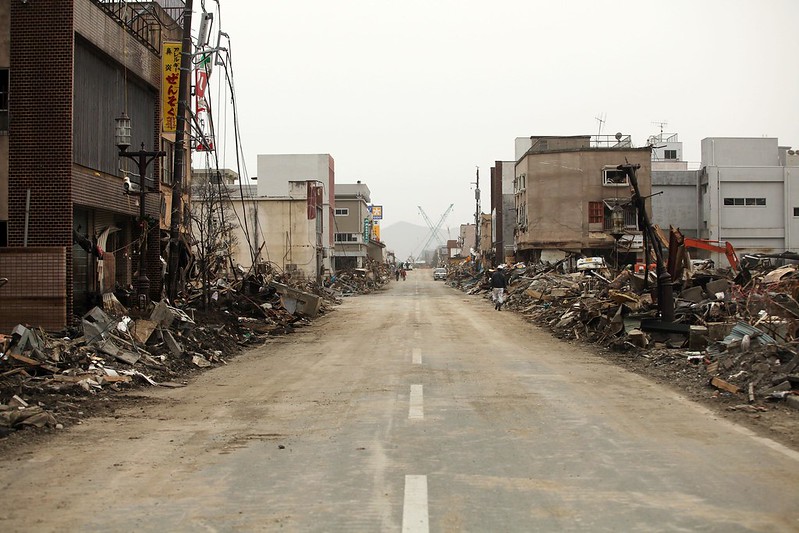 An urban road with ruined buildings on either side.