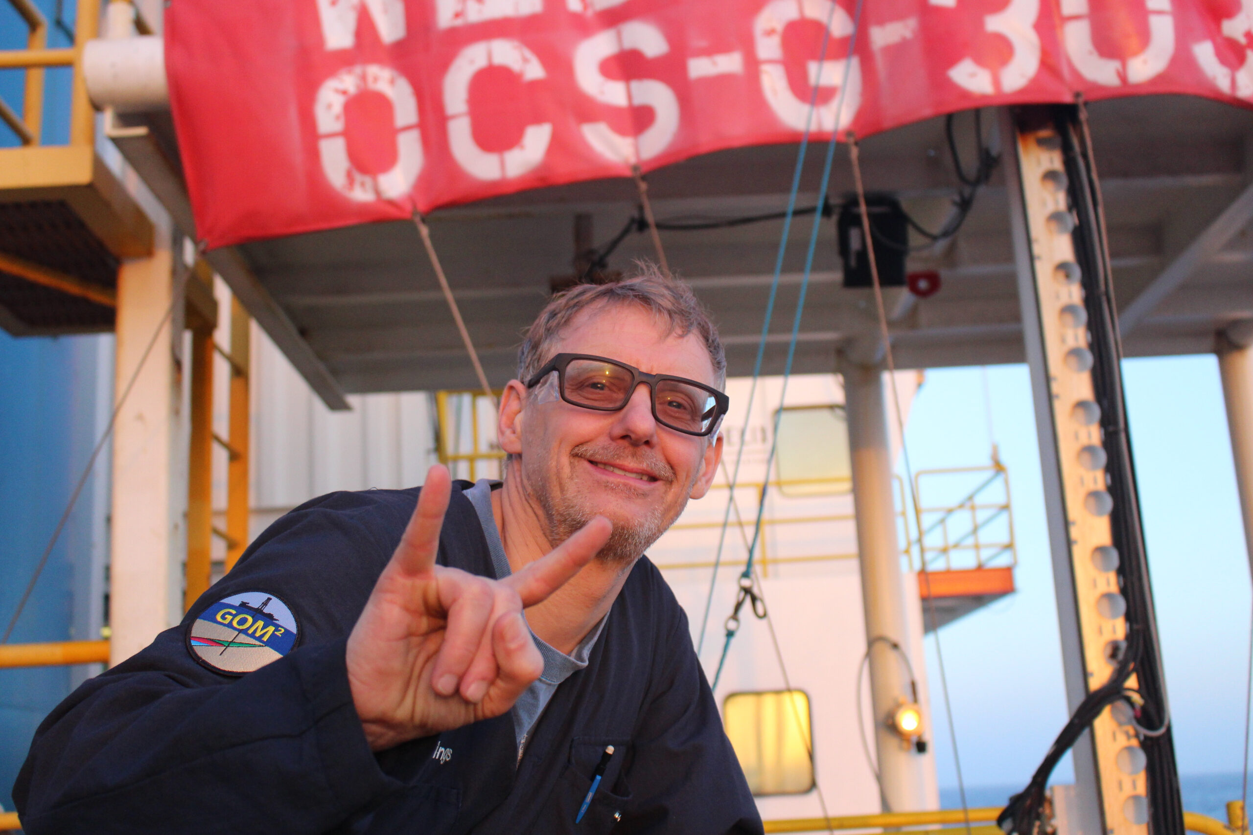 A photo of Peter Flemings with the deck of the deep-water coring vessel behind him.