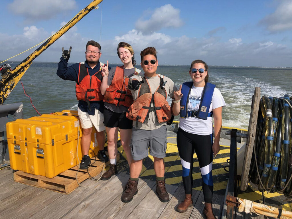 Photo of the students standing posing on the boat.