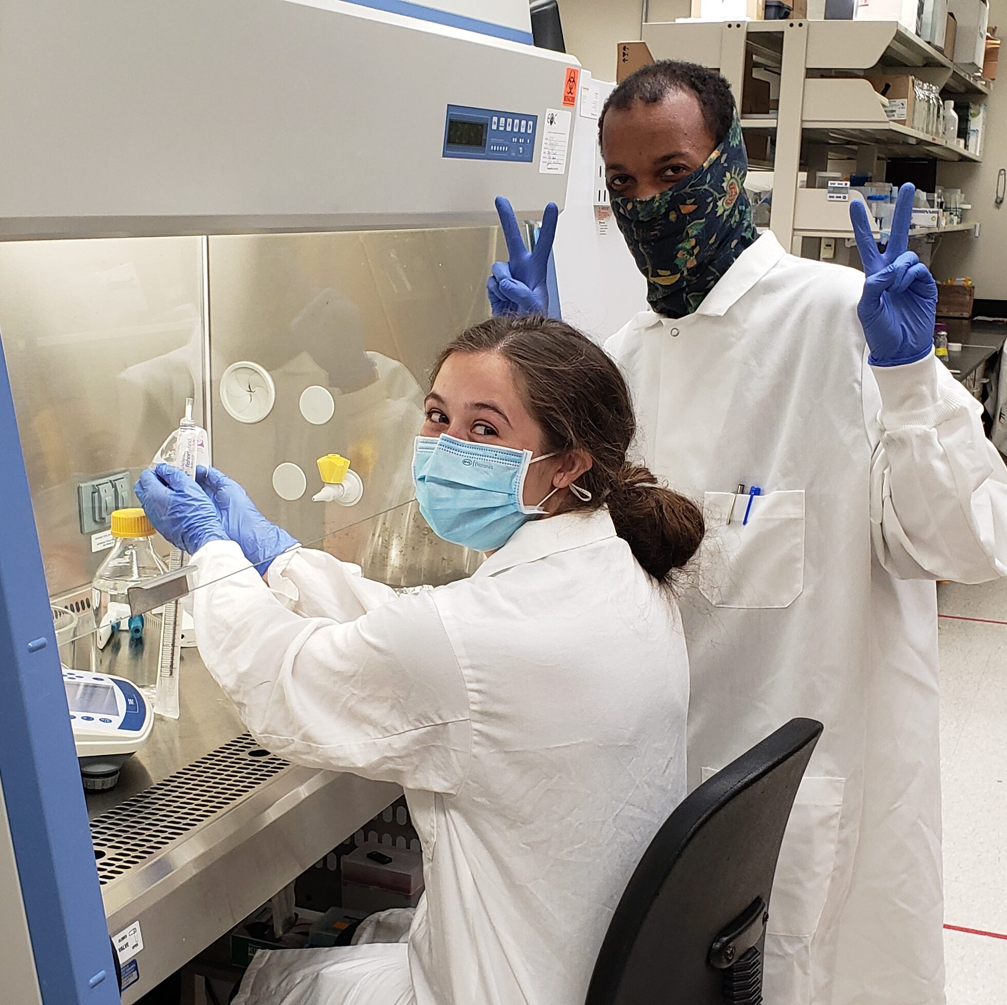 Addison and Lovell pose for the camera while working in the lab