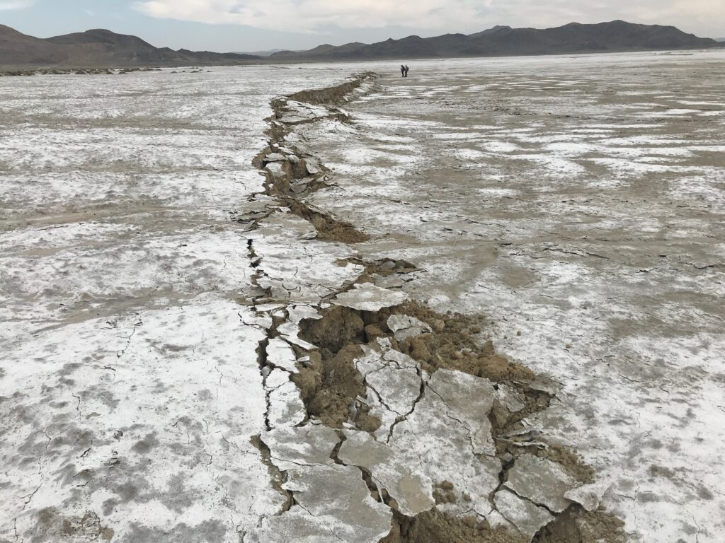 A crack in the Earth runs through a flat landscape