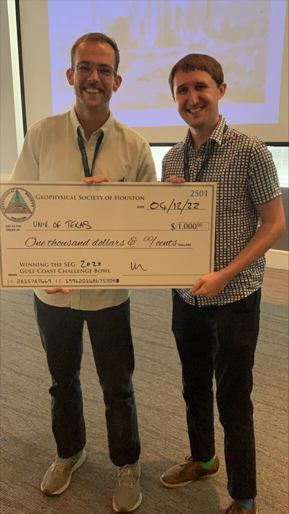 Ethan and Edward pose for the camera with their holding giant check.