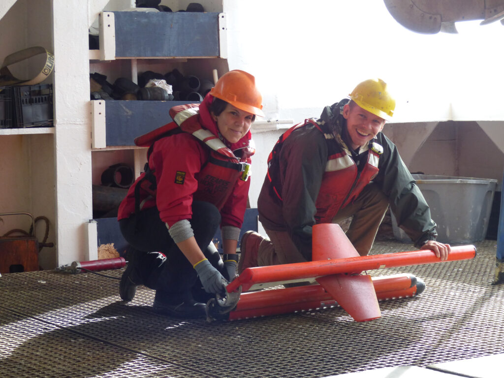 Students aboard the research vessel Marcus Langseth prepare a remote sensing instrument during an ocean survey of New Zealand's Hikurangi subduction zone. Former UTIG grad researcher Andrew Gase is on the right.