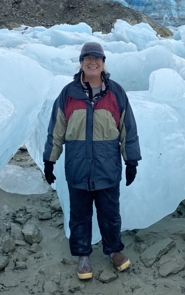 Picture of Gail surrounded by ice. She appears to be very happy.