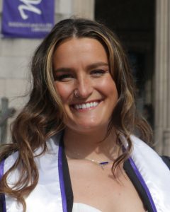 Portrait photo of Nicole wearing graduation gowns.