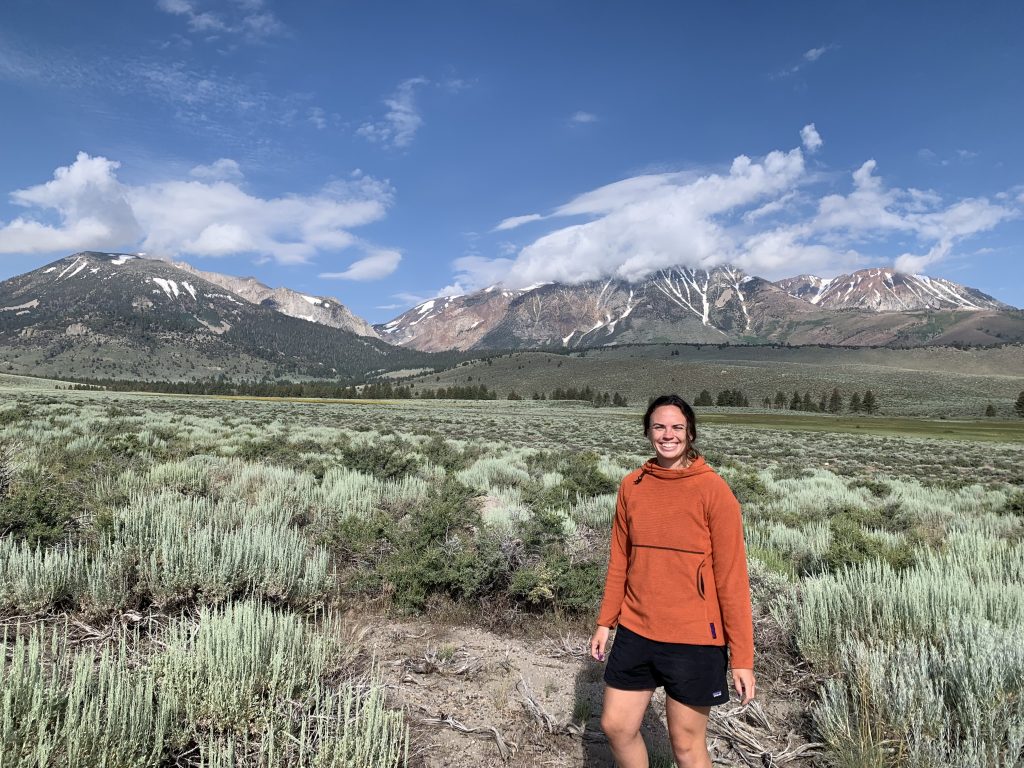 Photo of Kaitlin in front of a mountain landscape