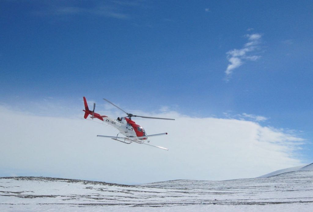 Photo of a helicopter flying over icy landscape