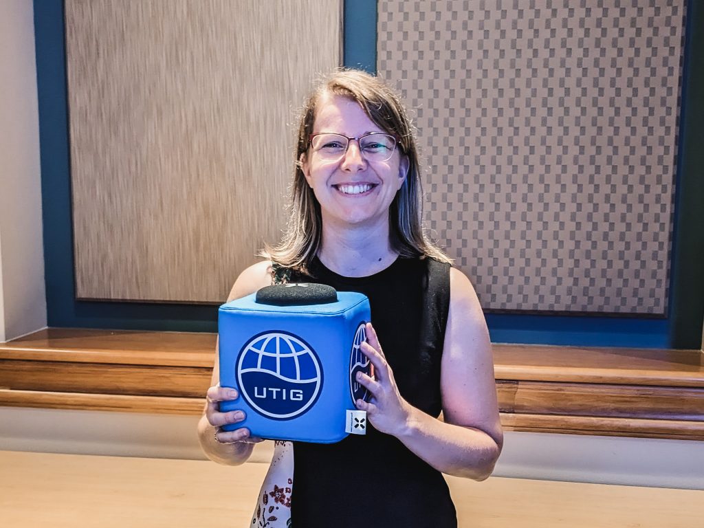 Photo of Anieke Brombacher holding the UTIG cube in the seminar room.
