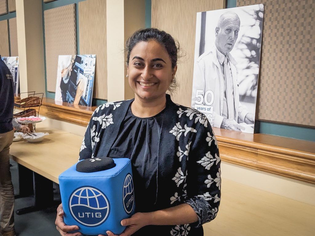 Photo of Geeta holding the UTIG cube in the seminar room.
