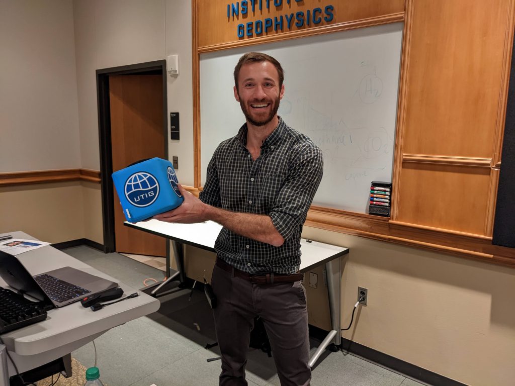 Photo of Jonathan Delph holding the UTIG cube.
