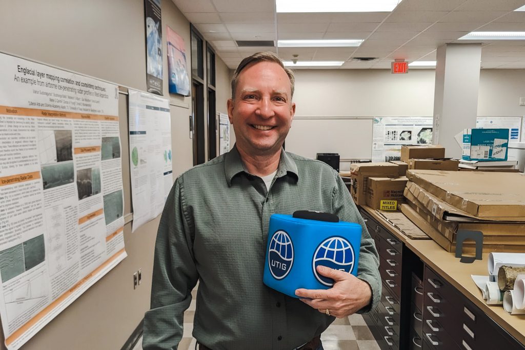 Photo of Tim Urban holding the UTIG cube.