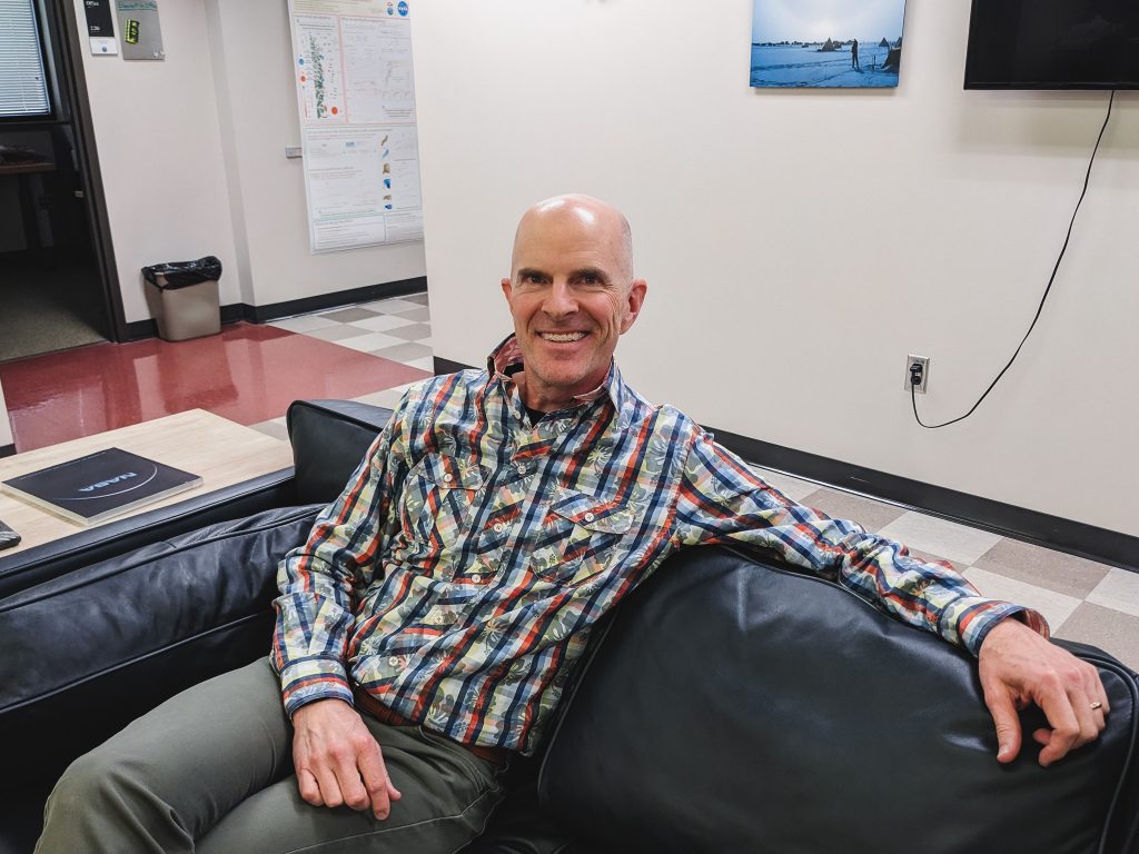 Photo of Michael sitting on a couch in the UTIG lobby.