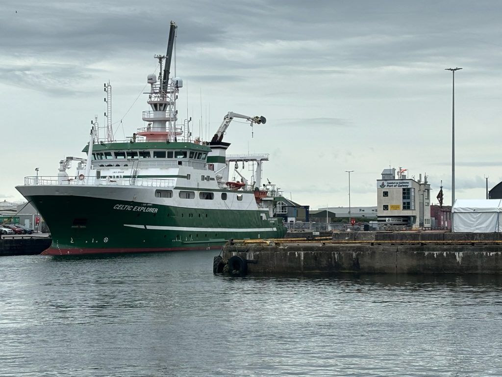 A photo of the docked ship. A sign indicating the port of Galway is nearby.