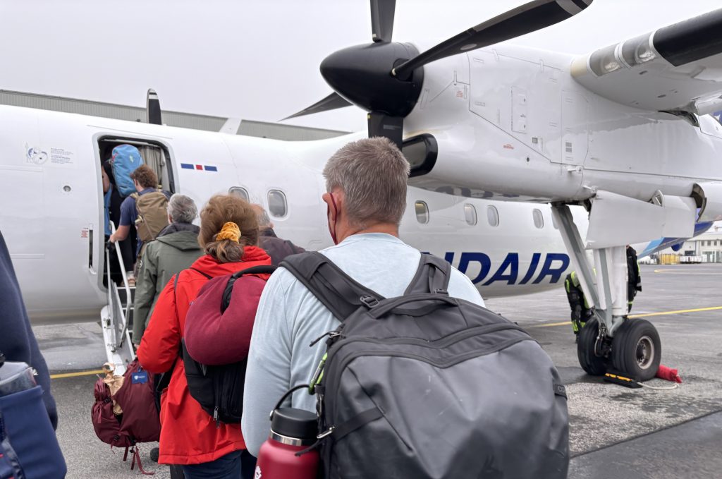 Photo of people boarding a propeller plane.