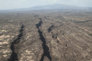 Aerial photo of rift canyons with a volcano in the distance.