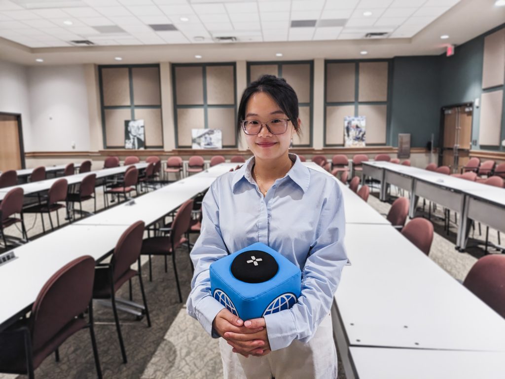 Photo of Chi holding the UTIG cube of truth in the seminar room.