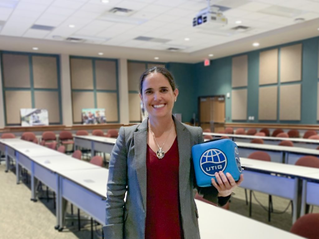 Picture of Tina holding the UTIG Cube of Truth in the seminar room.