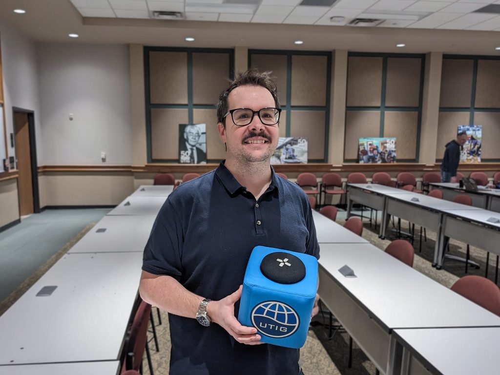 Picture of Eloi holding the UTIG of Cube in the seminar room.