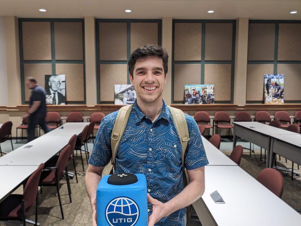 Photo of Gavin holding the UTIG Cube of Truth in the seminar room.