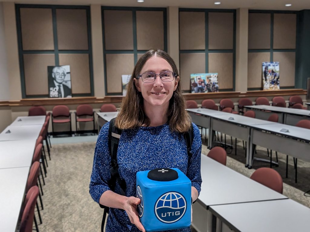 Picture of Marianne holding the UTIG Cube of Truth in the seminar room.