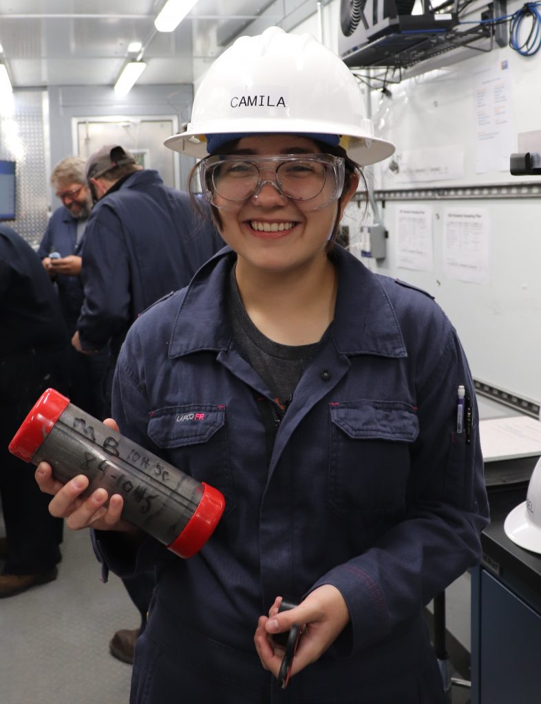 Picture of Camila holding a cartridge while wearing personal protective equiptment.