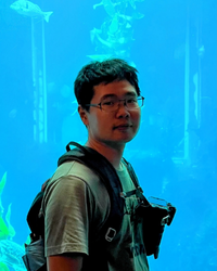 Photo of Chase in front of a blue aquarium.