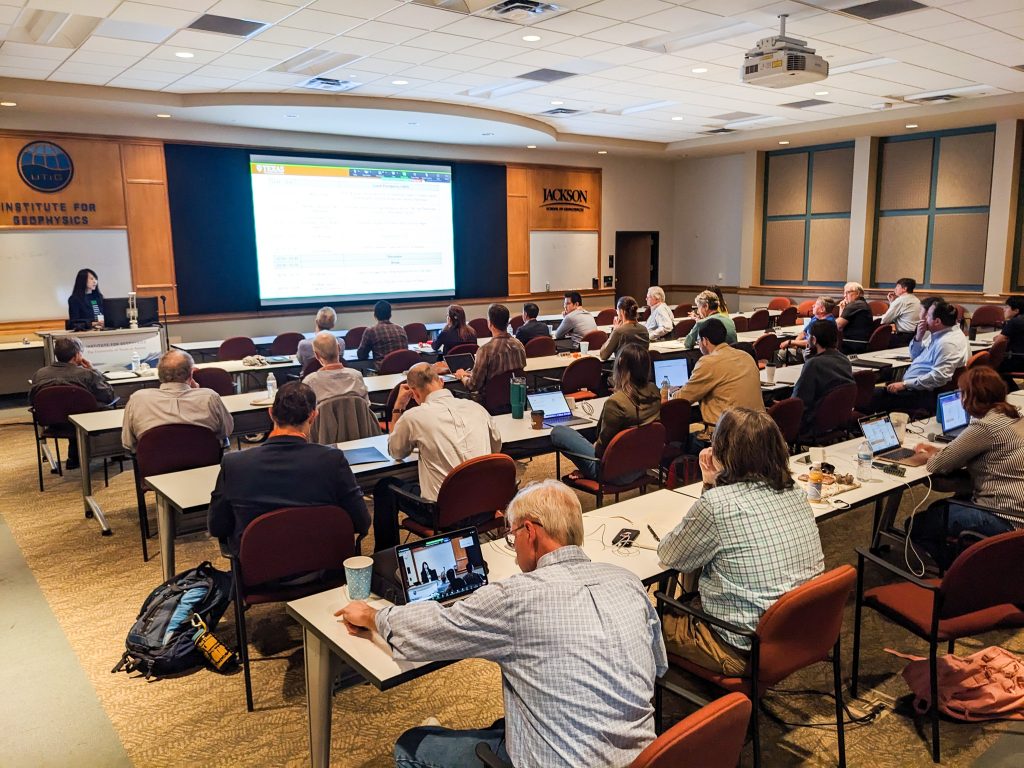 Photo of a conference room with participants listening to a speaker.