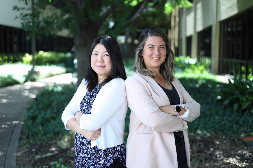 Photo of the two researchers back to back with arms folded.