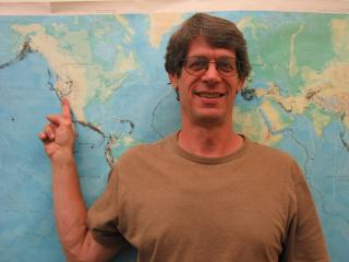 Picture of Gene pointing to a map in the back.