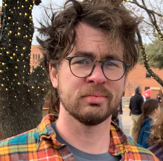 Photo of John. He is wearing glasses and a colorful shirt.