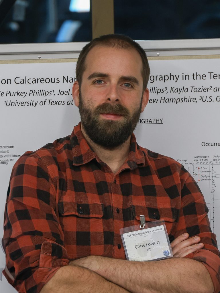 Photo of Chris, standing in front of a research poster.