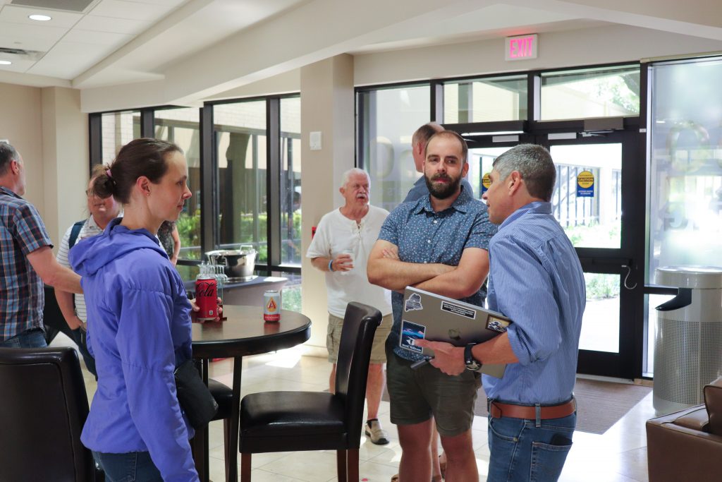 Photo of UTIG director Demian Saffer and Chris Lowery and Connie Rasmussen talking in the UTIG lobby.