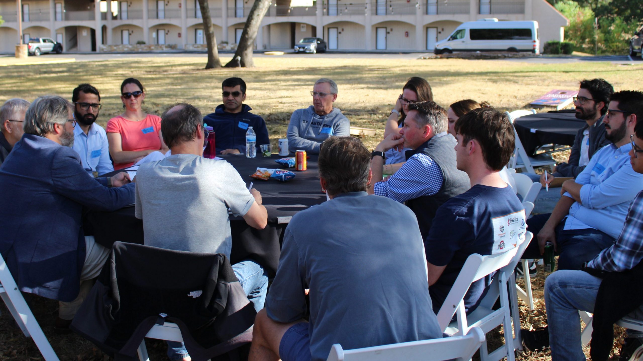 UT-GOM2 Science Team members in breakout team 1 gather around an outdoor table to discuss science related to Expedition UT-GOM2-2.