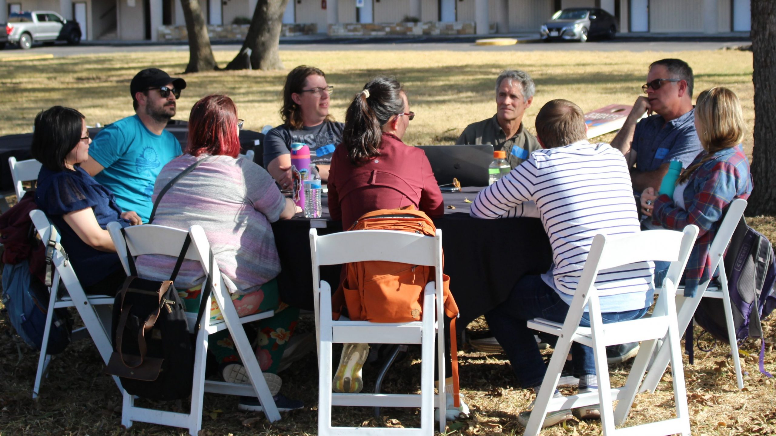 UT-GOM2 Science Team members in breakout team 2 gather around an outdoor table to discuss science related to Expedition UT-GOM2-2.
