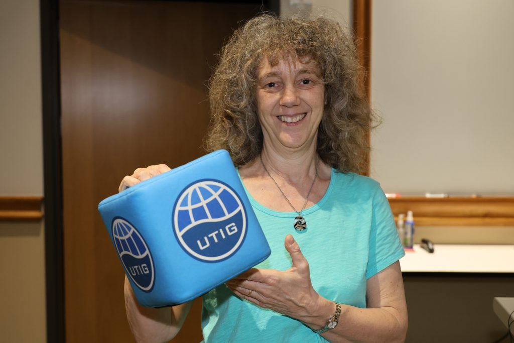 Rachel Abercrombie holding a soft cube with UTIG written on it.
